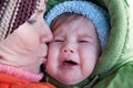 Grandmother kissing crying baby. Royalty Free Stock Photo