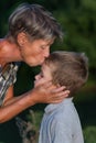 Grandmother kissing litlle grandson outdoor at evening Royalty Free Stock Photo