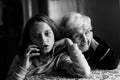 An grandmother listens as great-granddaughter talks on the phone.