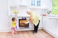 Grandmother and little girl baking pie in white kitchen Royalty Free Stock Photo