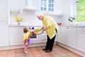 Grandmother and little girl baking pie in white kitchen Royalty Free Stock Photo