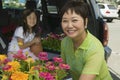 Grandmother Loading Various Flowers In Car