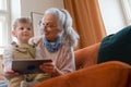 Grandmother looking fairytale with her grandson on digital tablet. Royalty Free Stock Photo
