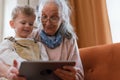 Grandmother looking fairytale with her grandson on digital tablet. Royalty Free Stock Photo