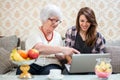 Grandmother looking at laptop with her granddaughter at home. Royalty Free Stock Photo