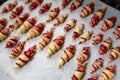 Grandmother making handmade tasty butter rolling cookies with fruit and berry jam on oven tray before baking at kitchen Royalty Free Stock Photo