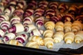 Grandmother making handmade tasty butter rolling cookies with fruit and berry jam on oven tray before baking at kitchen Royalty Free Stock Photo