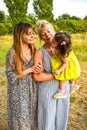 Grandmother, Mother And Daughter Relaxing In Park. Three generations are playing together in the garden Royalty Free Stock Photo