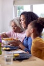 Grandmother With Mother And Granddaughter Enjoying Multi-Generation Family Meal At Home Royalty Free Stock Photo