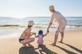 Grandmother, mother and little daughter at the beach looking at the ocean