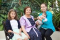 Grandmother, mother with teenage daughter and toddler on hands, portrait of females being close