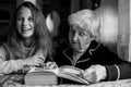 Grandmother - an old woman with granddaughter a little girl - reading a book. Emotion. Royalty Free Stock Photo