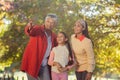 Grandmother pointing while standing with daughter and granddaughter at park Royalty Free Stock Photo