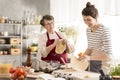 Grandmother preparing pizza with granddaughter