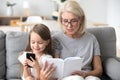 Grandmother read book to addicted to smartphone little kid Royalty Free Stock Photo