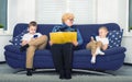 Grandmother reads a book to children, and they play on mobile phones. A social problem. Royalty Free Stock Photo