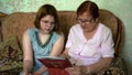 The grandmother shows her granddaughter her old photos from the family album. A happy family