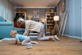 Grandmother of single mother taking care of her young baby, playing on the apartment floor. Senior woman babysitting her grandson Royalty Free Stock Photo