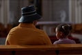 Grandmother sitting with her little girl in church