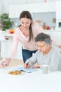 Grandmother solving crosswords puzzle helped help by grand daughter Royalty Free Stock Photo