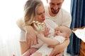 Grandmother and son are playing with their little grandson in a bright room, all dressed in white T-shirts. Loving Royalty Free Stock Photo