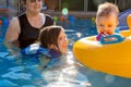 Grandmother Swims with Two Grandchildren A Young Girl Smiles Up