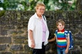 Grandmother taking child, kid boy to school on his first day