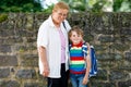 Grandmother taking child, kid boy to school on his first day