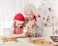 Grandmother teach granddaughter decorate cookies Royalty Free Stock Photo