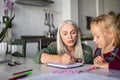 Grandmother teaching to granddaughter at home