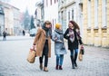 Grandmother and teenage grandchildren with bags walking down the street in winter. Royalty Free Stock Photo