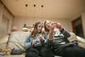 Grandmother and teenage granddaughter knitting on a sofa. Grandma teaching teen child to knit