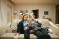 Grandmother and teenage granddaughter knitting on a sofa. Grandma teaching teen child to knit Royalty Free Stock Photo