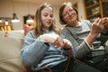 Grandmother and teenage granddaughter knitting on a sofa. Grandma teaching teen child to knit