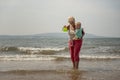 Grandmother and two year old grandson playing in the sea