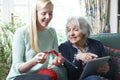 Grandmother Using Digital Tablet Whilst Granddaughter Knits Royalty Free Stock Photo