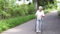 Grandmother walks with Nordic walking sticks old grey