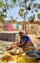 grandmother working on old stone wheel flour mill and making chickpeas wheat.