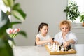 Grandmother and young girl playing chess together at home