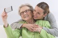 Grandmother and young grand-daughter photographing themselves Royalty Free Stock Photo