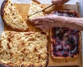 Grandmothers hands cut delicious pies cooked in a traditional Russian oven with a knife.