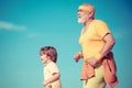 Grandpa and child sportsmen jogging outdoors and enjoying sunny day. Like sports. Funny sporty old sportsman and cute