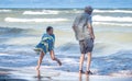 Grandpa and granddaughter on the beach