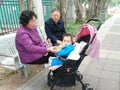 Shenzhen, China: Grandparents and grandchildren rest on the sidewalk