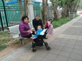 Shenzhen, China: Grandparents and grandchildren rest on the sidewalk