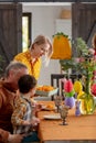 Grandpa, grandson and mother are getting ready for Easter dinner. At the table in the house, beside a decoration of paper eggs Royalty Free Stock Photo