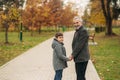 Grandpa and grandson spend time in autumn park. They hug each other and walk. Fmily time Royalty Free Stock Photo