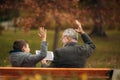 Grandpa and his grandson spend time together in the park. They are sitting on the bench. Walking in the park and Royalty Free Stock Photo