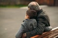 Grandpa and his grandson spend time together in the park. They are sitting on the bench. Walking in the park and Royalty Free Stock Photo