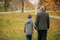 Grandpa and his grandson are walking in the park. The spend time together Royalty Free Stock Photo